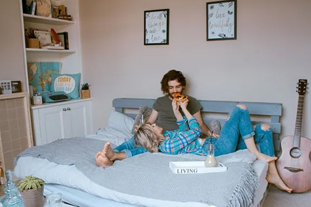 Woman feeding man pizza